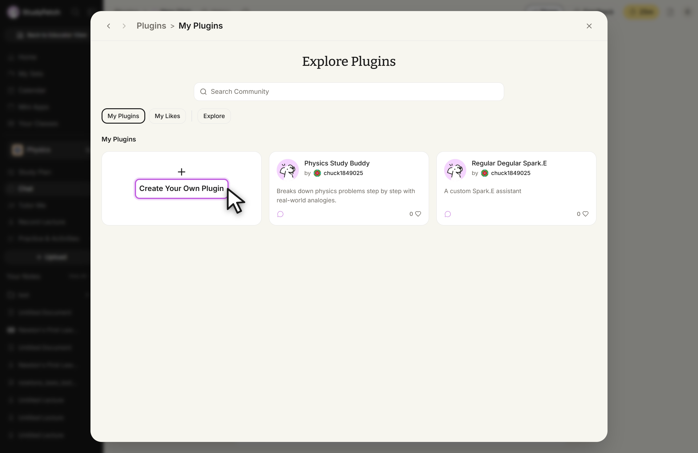Plugins modal headed Explore Plugins with the breadcrumb Plugins, My Plugins, a Search Community field, and the My Plugins tab selected. Under My Plugins are three cards: Create Your Own Plugin, outlined with the cursor on it, Physics Study Buddy by chuck1849025, described as Breaks down physics problems step by step with real-world analogies, and Regular Degular Spark.E by chuck1849025, described as A custom Spark.E assistant. Both existing plugins show 0 likes.